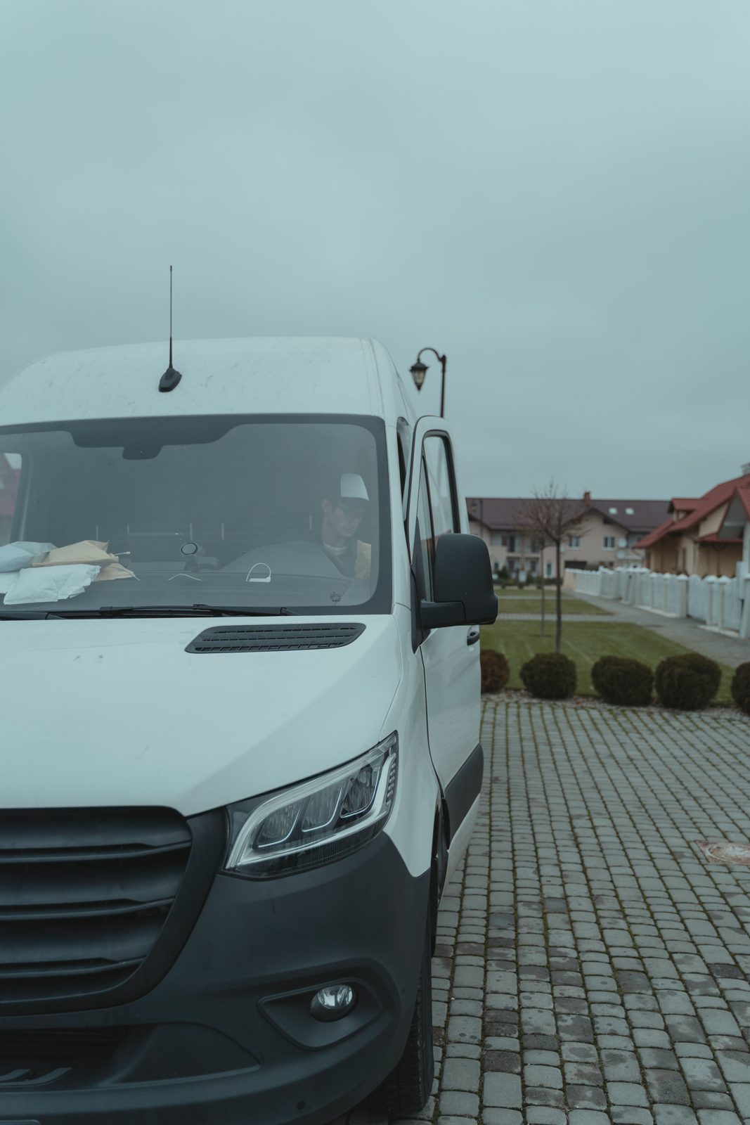 Weißer Liefertransporter bei der Auslieferung an einen Kunden